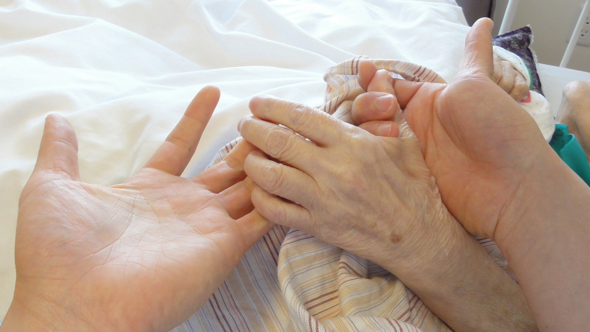 八王子市で訪問マッサージを行う様子 手を添えて安心できる施術